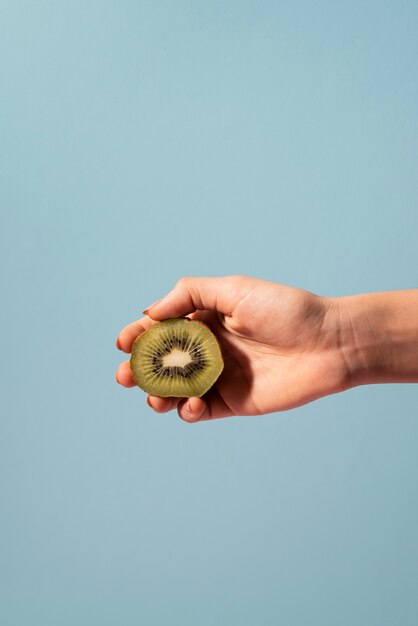 Close up hand holding kiwi