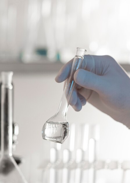 Close-up hand holding lab glassware