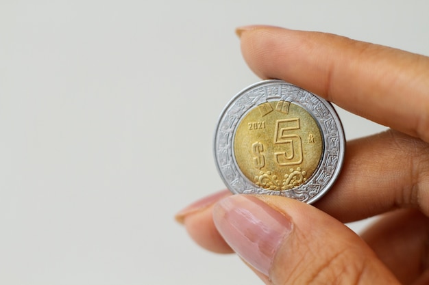 Close up hand holding mexican coin