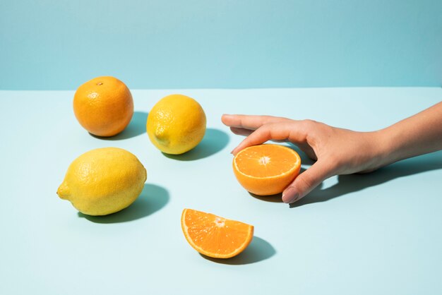 Закройте руку, держащую апельсин