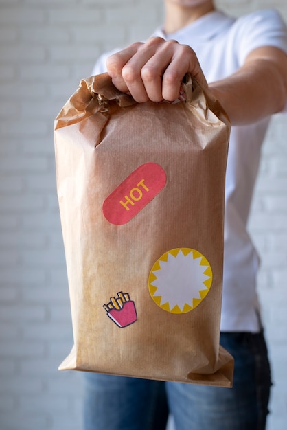 Free photo close up hand holding paper bag