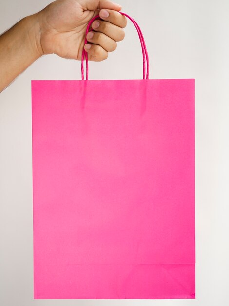 Close-up hand holding a pink bag mock-up