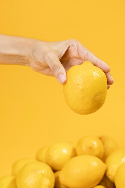 Foto gratuita mano del primo piano che tiene limone crudo