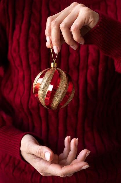 Close up hand holding red and golden globe