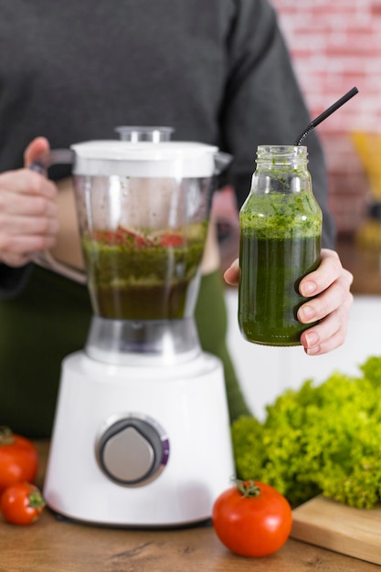 Free photo close up hand holding smoothie bottle