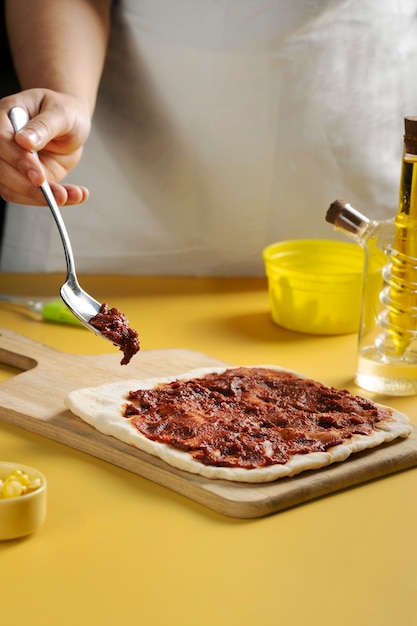 Close up hand holding spoon with sauce