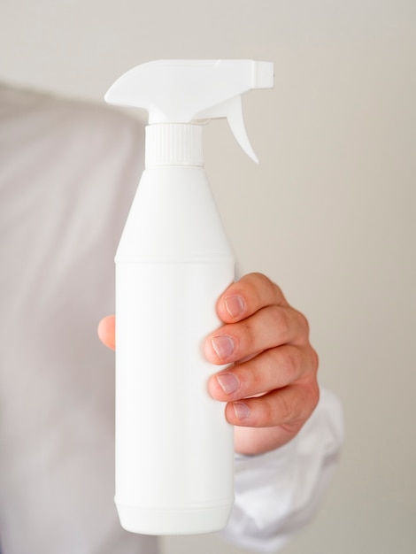 Free photo close-up hand holding spray bottle mock-up