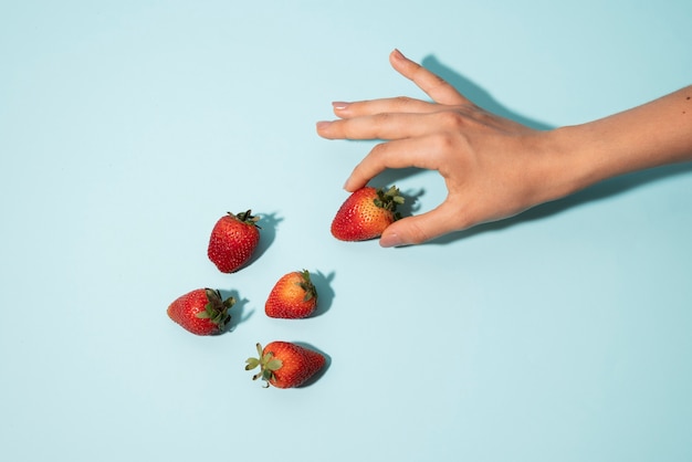 Free photo close up hand holding strawberry