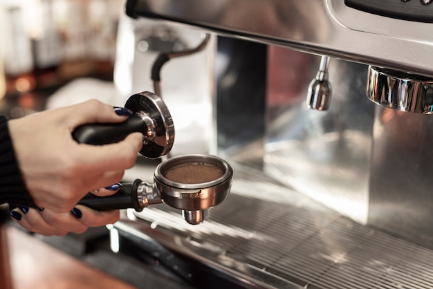 Close-up hand holding tamper and coffee filter