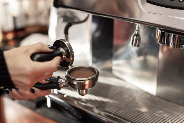 Close-up hand holding tamper and coffee filter