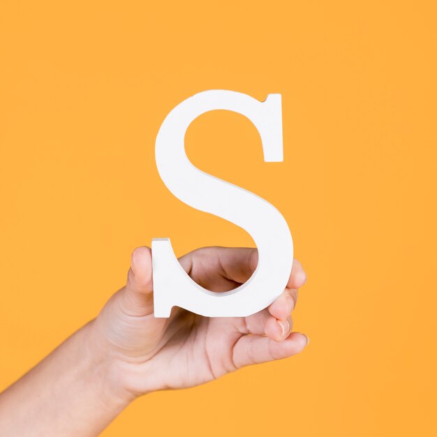 Close-up of a hand holding up the alphabet s