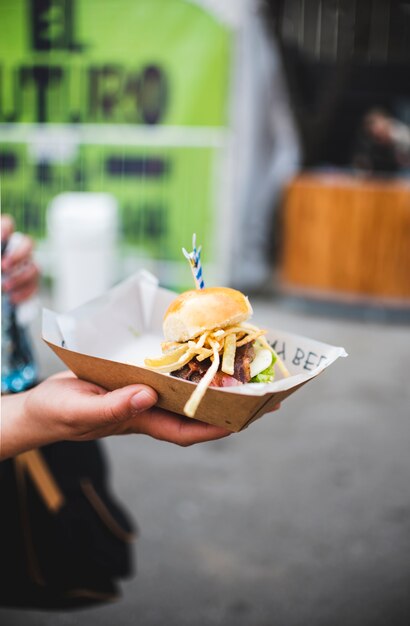 Close-up hand holding up a burger 