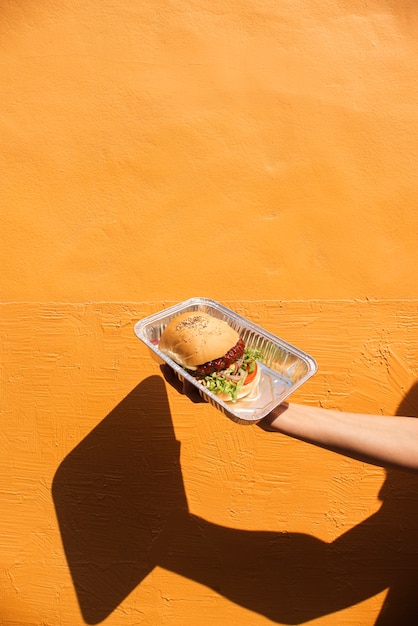 Close-up hand holding up delicious burger