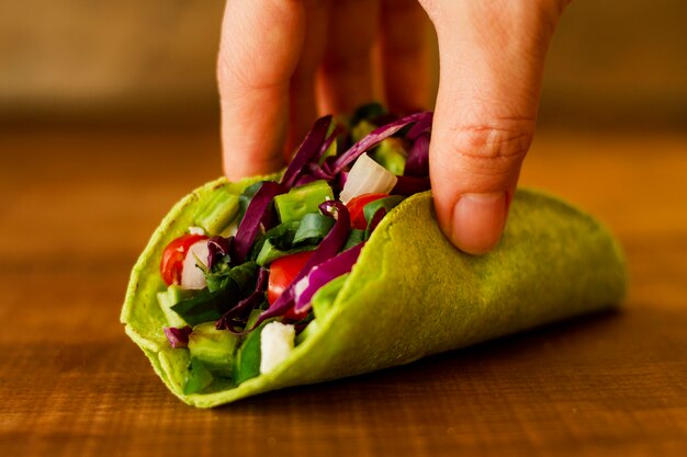 Close-up hand holding vegetarian taco