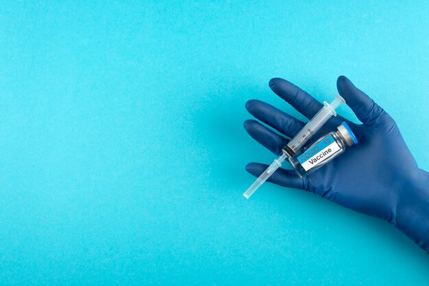 Close up hand holding vial and syringe