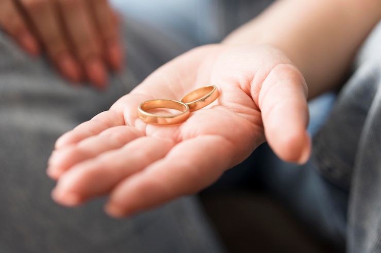 Free Photo close-up hand holding wedding rings