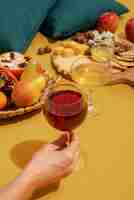 Foto gratuita chiuda sulla mano che tiene il bicchiere di vino