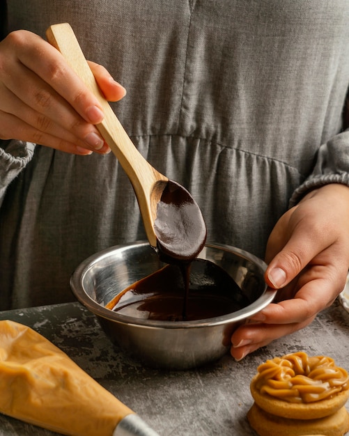 Close up hand holding wooden spoon with chocolate