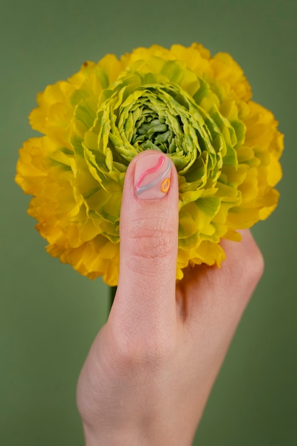 Close up hand holding yellow flower