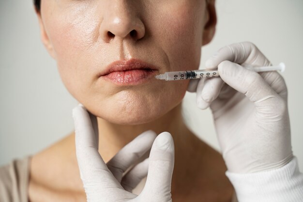 Close up hand injecting woman's lip