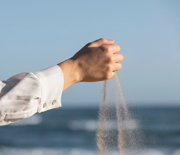 Close up hand letting go of sand