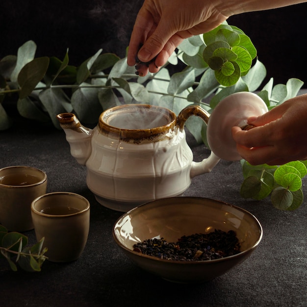 Foto gratuita mano del primo piano che fa il tè nella pentola