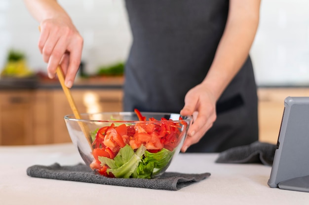 Close up hand mixing salad