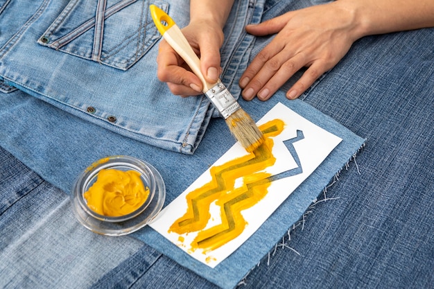 Free photo close-up hand painting jeans