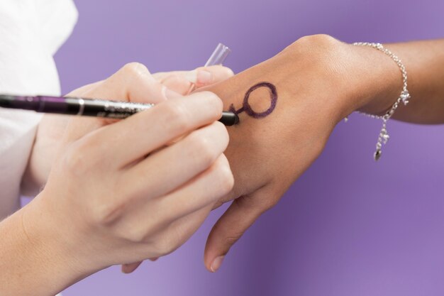 Close-up hand painting with feminism symbol