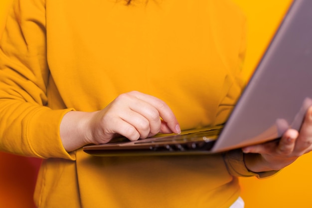 Close up of hand of person using modern laptop and working on internet connection. Young adult holding digital computer with online technology, browsing website network for work.