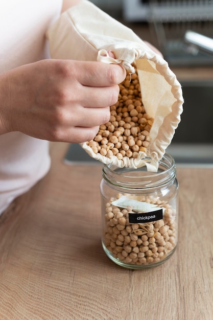 Close up hand pouring chickpeas from bag