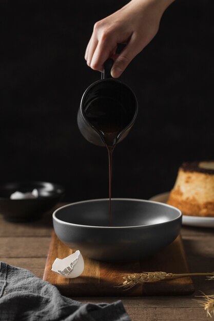 Close-up hand pouring chocolate into pan