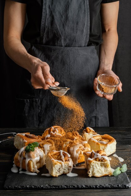 Free photo close up hand pouring cinnamon on dessert