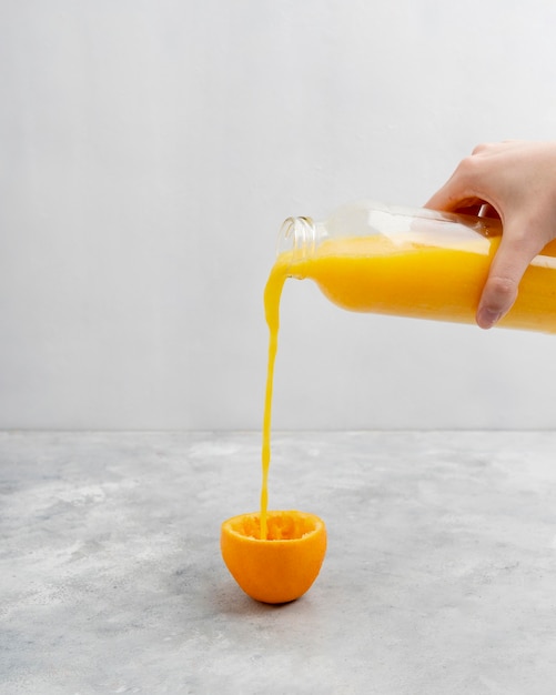 Close-up hand pouring juice in glass