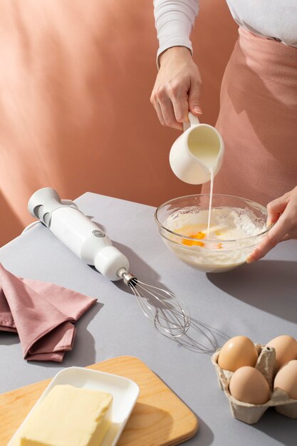 Close up hand pouring milk in bowl