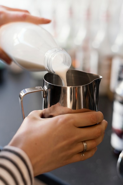 Close up hand pouring milk in cup