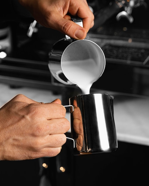 Free photo close-up hand pouring milk