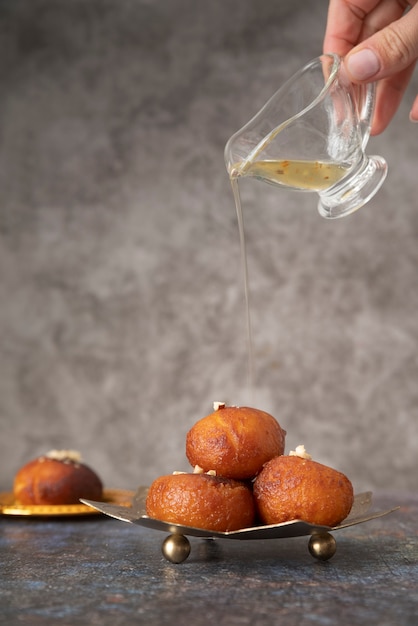 Foto gratuita chiuda sulla mano che versa lo sciroppo sul dessert