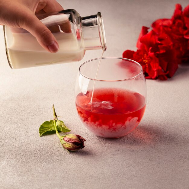 Close-up hand pouring syrup in tea