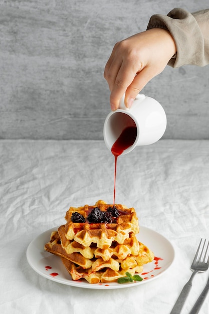 Close-up hand pouring syrup