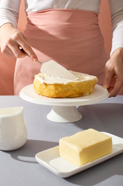 Close up hand preparing cake