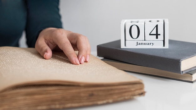 Free photo close-up hand reading old braille book