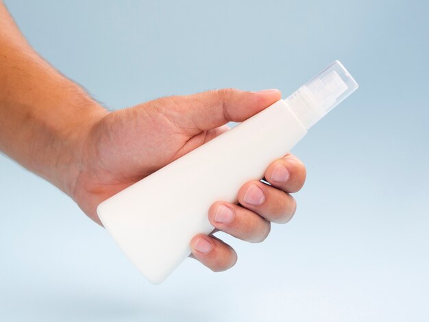 Close-up hand showing lotion bottle mock-up