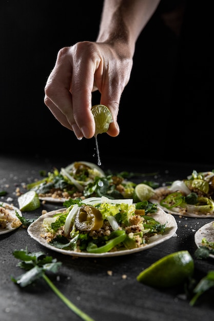 Free photo close-up hand squeezing lime on taco