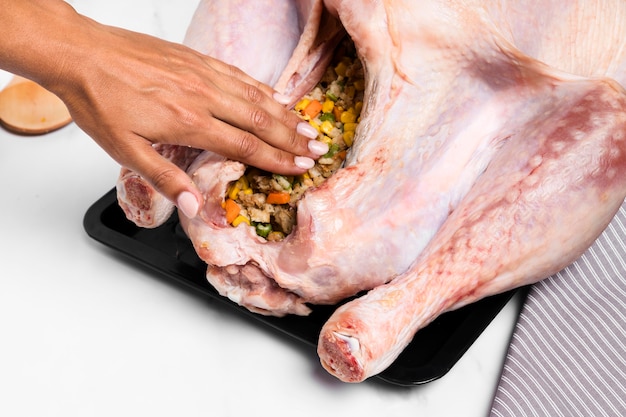 Close-up hand stuffing thanksgiving turkey