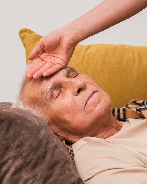 Close-up hand taking old man's temperature