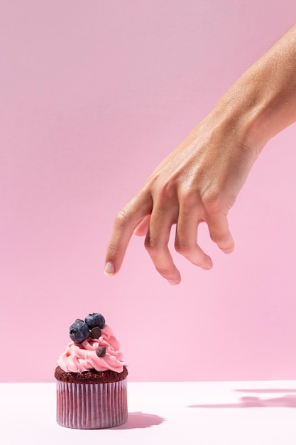 Close-up hand and tasty cupcake