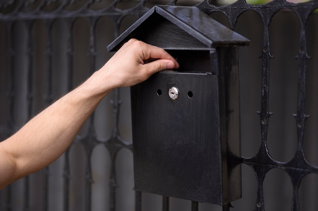 Close-up hand touching mailbox