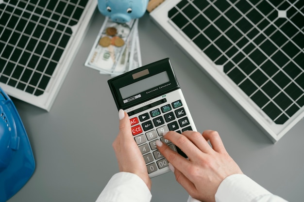 Close up hand typing on pocket calculator