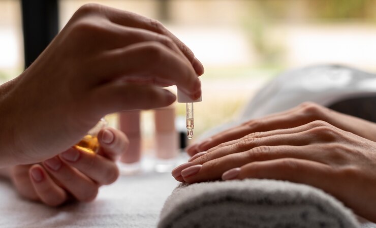 Close up hand using nail oil